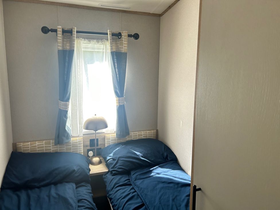 A bedroom with two beds and a lamp at The Old Barn in Manchester