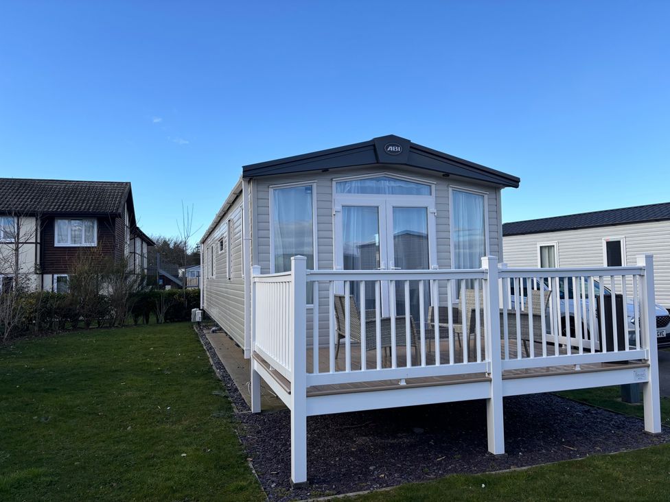 A mobile home with a deck and railing at a residential area