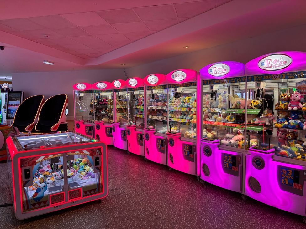 An arcade with claw machines and plush toys at an entertainment center