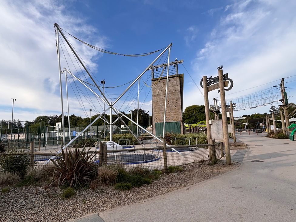 An outdoor area with a climbing tower and ropes course at a recreational facility