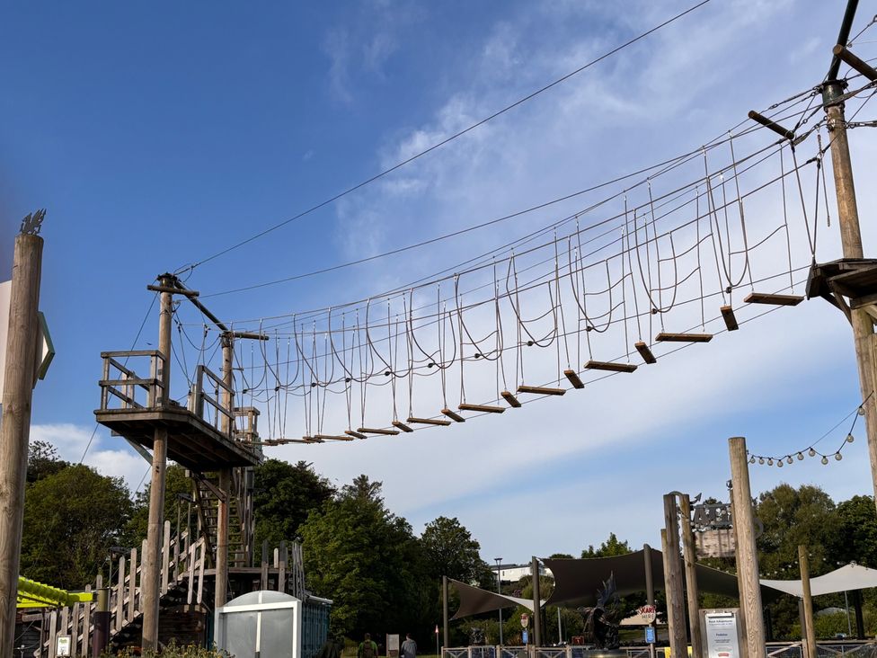 A rope bridge connecting two platforms at an outdoor adventure park