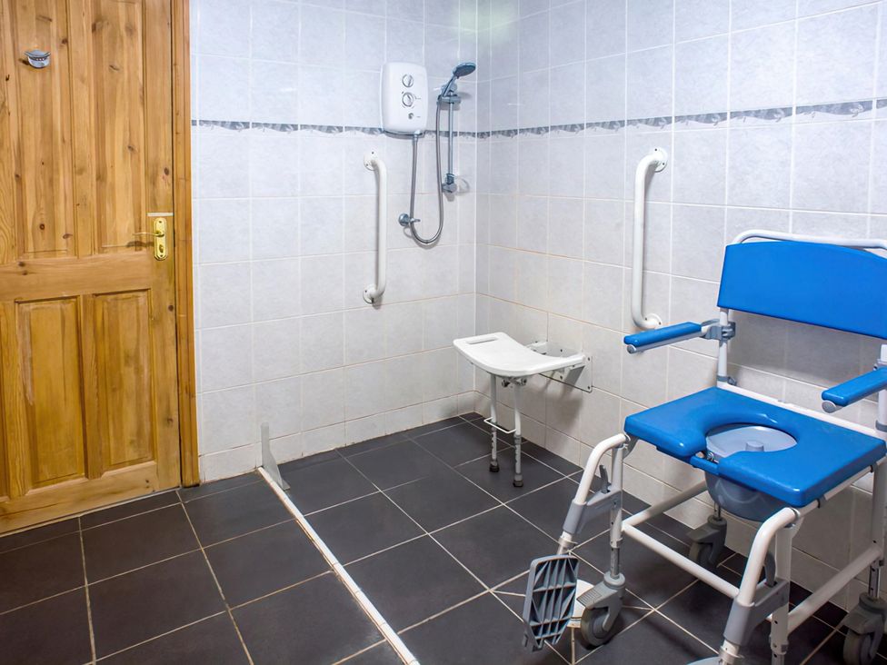 A bathroom with a shower chair and grab bars at Accessible 4-Bed Barn, Sleeps 8 - Farm Stay near Mayfield