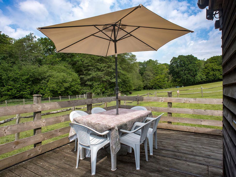 An outdoor area with a table and chairs under an umbrella at Accessible 4-Bed Barn, Sleeps 8 - Farm Stay near Mayfield