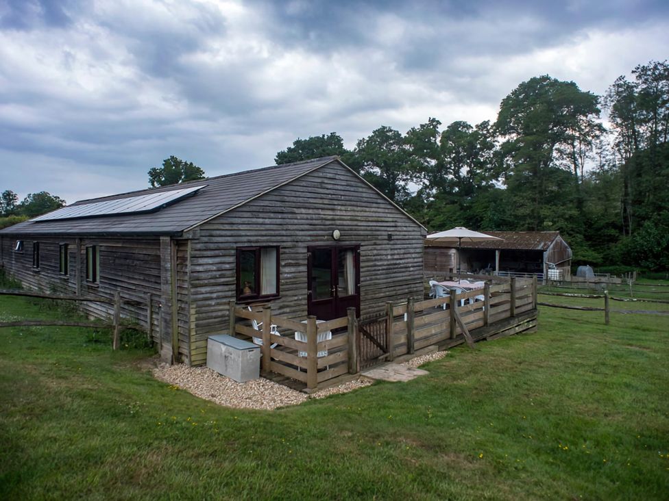 A wooden building with a fence and solar panels at Accessible 4-Bed Barn, Sleeps 8 - Farm Stay, The Games Barn near Mayfield