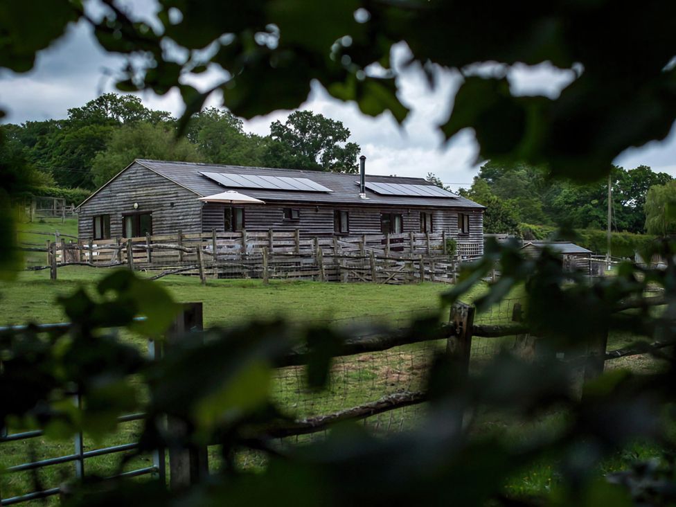 A barn surrounded by a fence and grass at Accessible 4-Bed Barn, Sleeps 8 - Farm Stay, The Games Barn near Mayfield