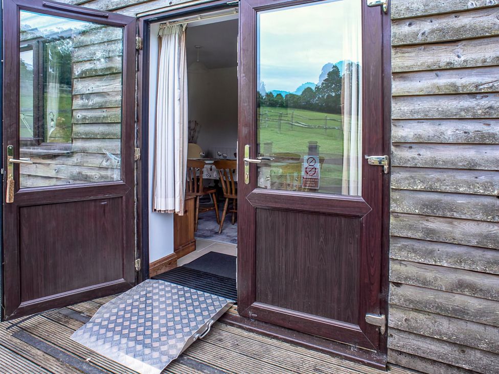 Double doors leading to a dining area with a table and chairs at Accessible 4-Bed Barn, Sleeps 8 - Farm Stay near Mayfield
