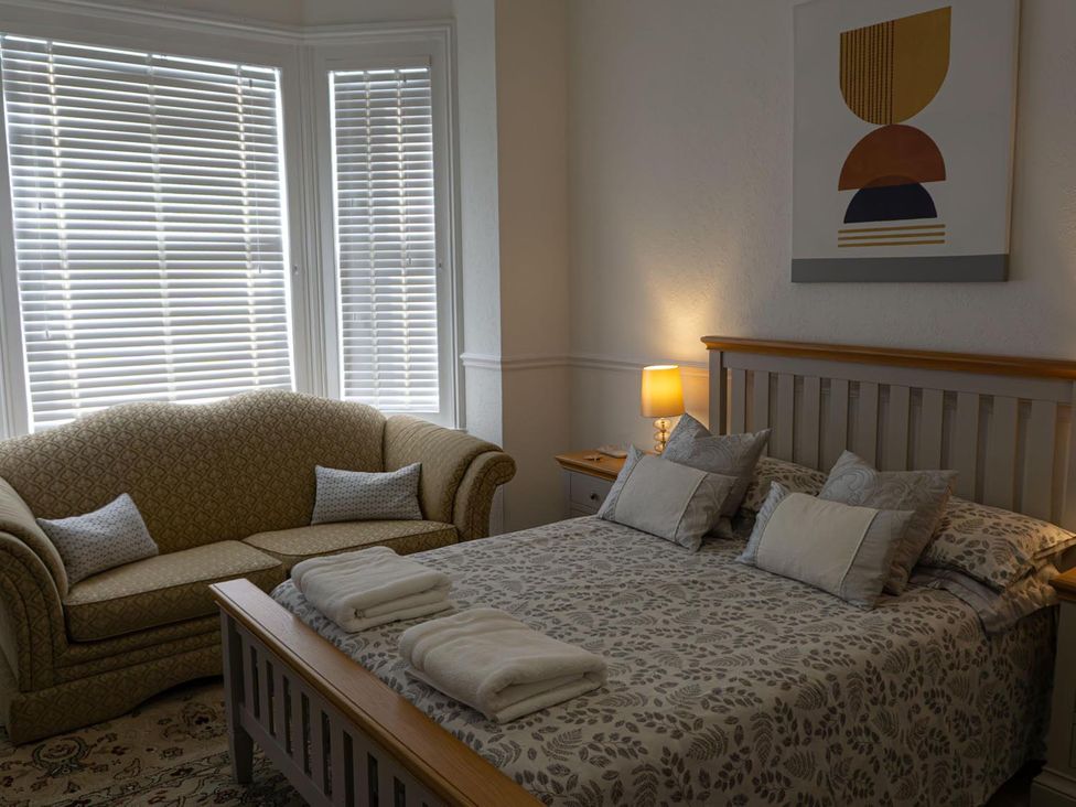 A bedroom with a bed and a sofa at Lovely, spacious apartment - sleeps 5 in Ryde