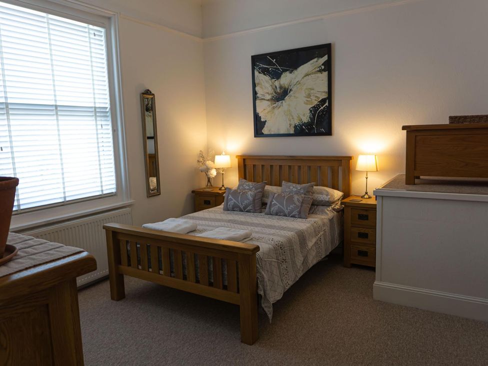 A bedroom with a bed, bedside tables, and a mirror at Lovely, spacious apartment - sleeps 5 in Ryde
