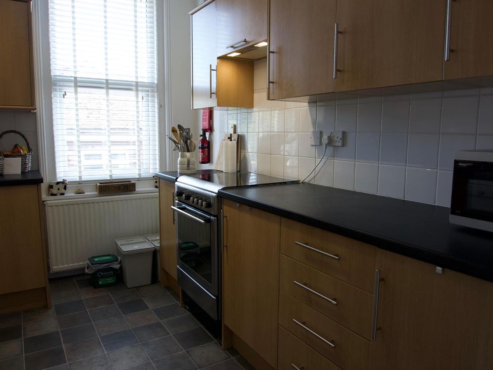 A kitchen with cabinets, oven, and microwave at Lovely, spacious apartment - sleeps 5 in Ryde