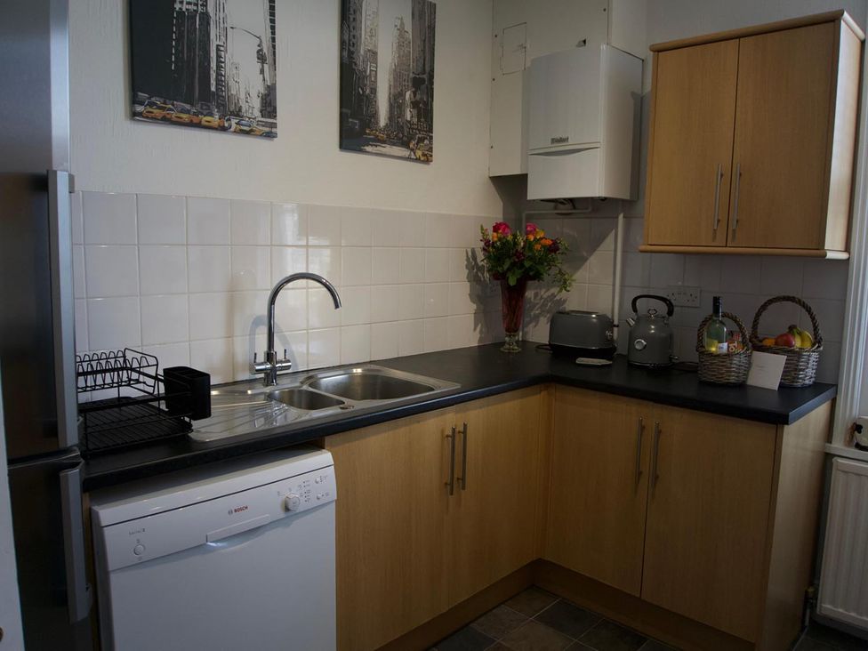 A kitchen with cabinets, sink, and appliances at Lovely, spacious apartment - sleeps 5 Ryde