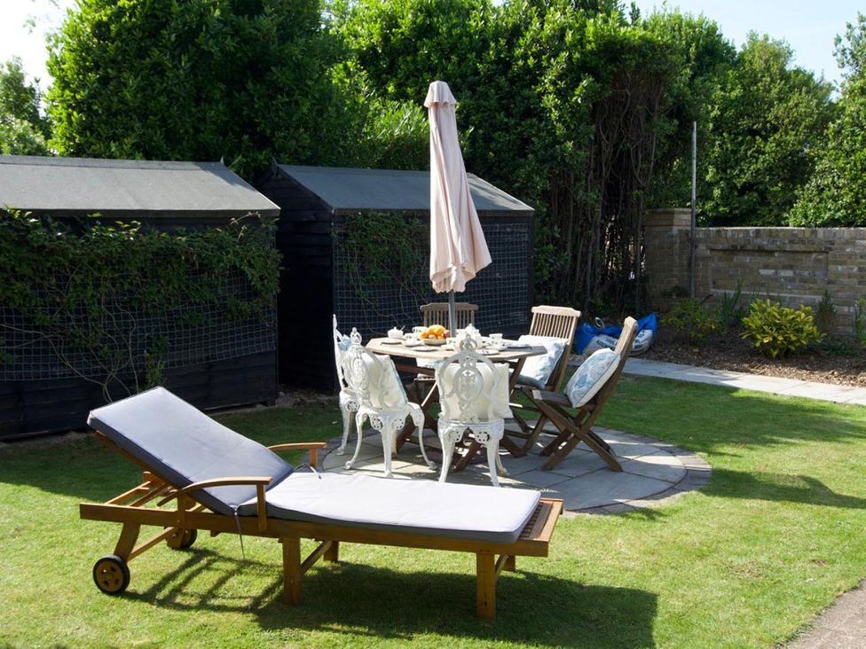 A garden with a sun lounger and dining set at Lovely, spacious apartment - sleeps 5 Ryde