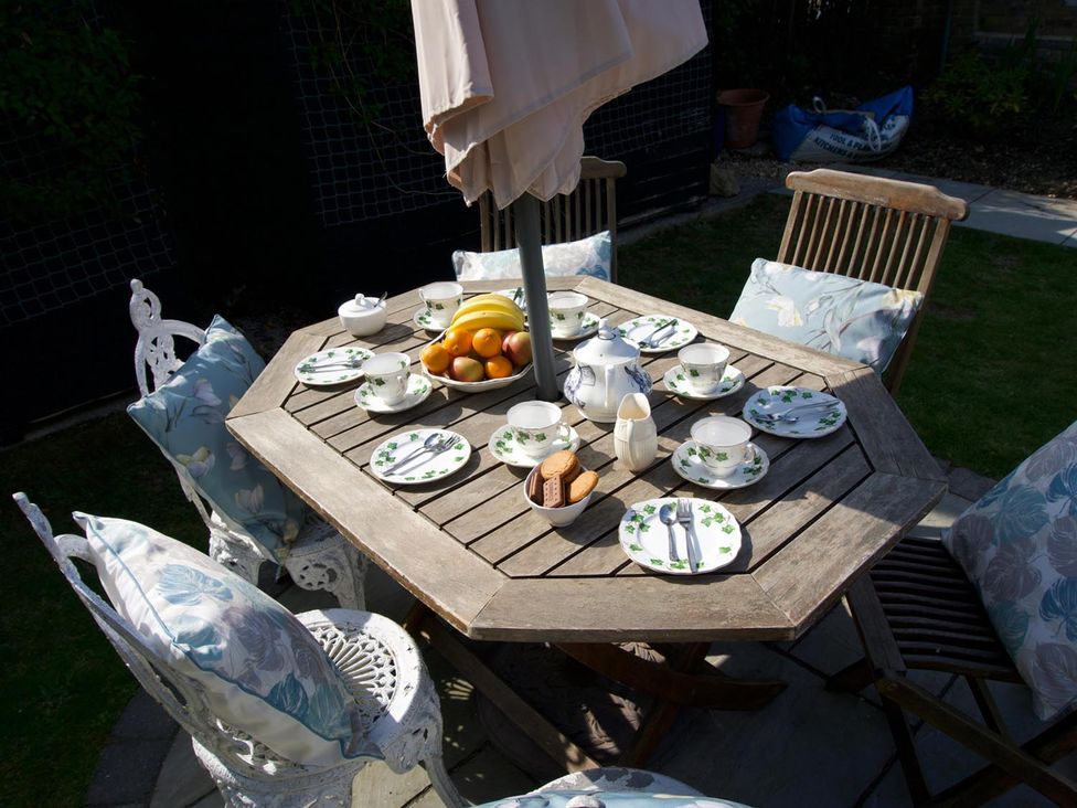 A dining table set with tea set and fruits at Lovely, spacious apartment - sleeps 5 in Ryde