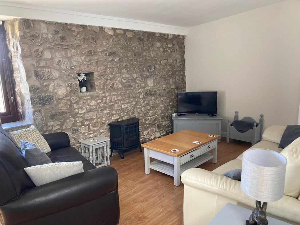A living room with a stone wall and television at Vale of Glamorgan - Cottage - Sleeps 4 - Parking Llancarfan near St Athan