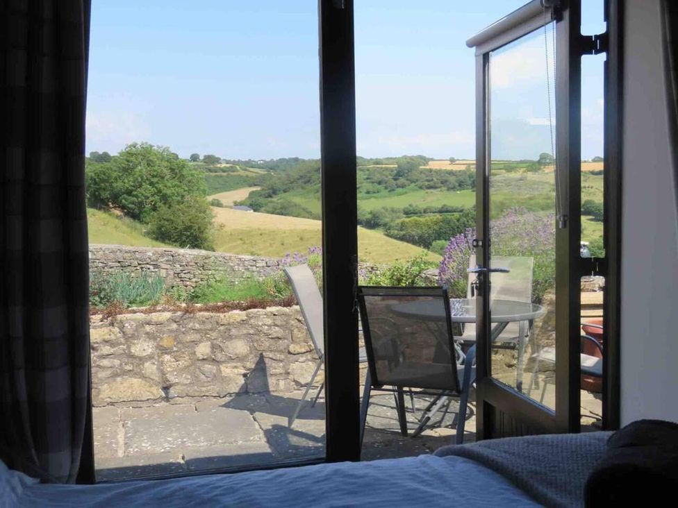 A view from inside to an outdoor seating area at Vale of Glamorgan - Cottage - Sleeps 4 - Parking in Llancarfan near St Athan
