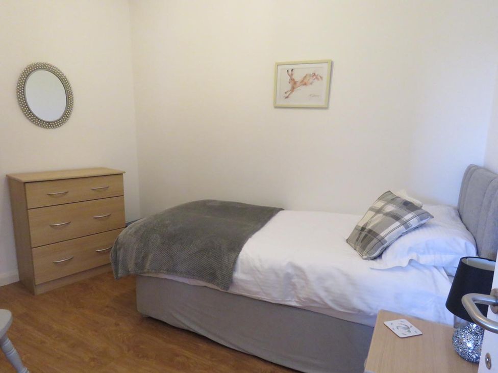A bedroom with a single bed and a wooden dresser at Vale of Glamorgan - Cottage - Sleeps 4 - Parking, Llancarfan near St Athan