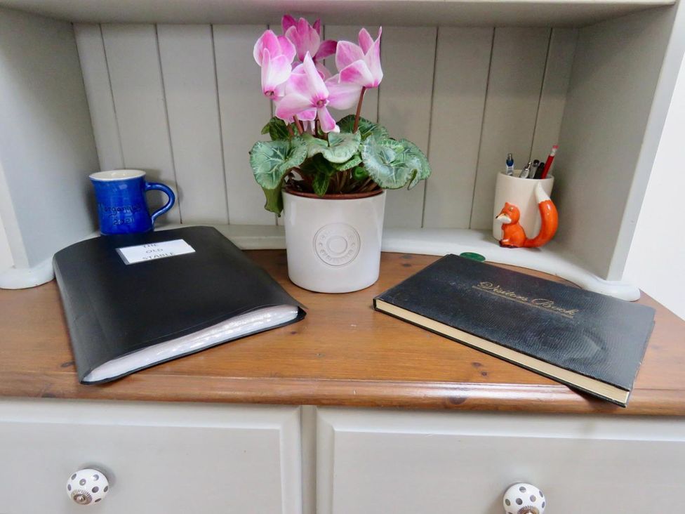 A desk with folders, a mug, a plant, and a notebook at Vale of Glamorgan - Cottage - Sleeps 4 - Parking in Llancarfan near St Athan
