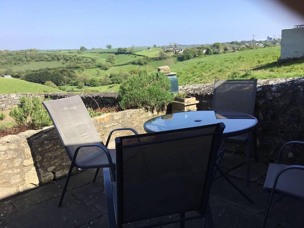 An outdoor seating area with a table and chairs overlooking the scenery at Vale of Glamorgan - Cottage - Sleeps 4 - Parking in Llancarfan near St Athan
