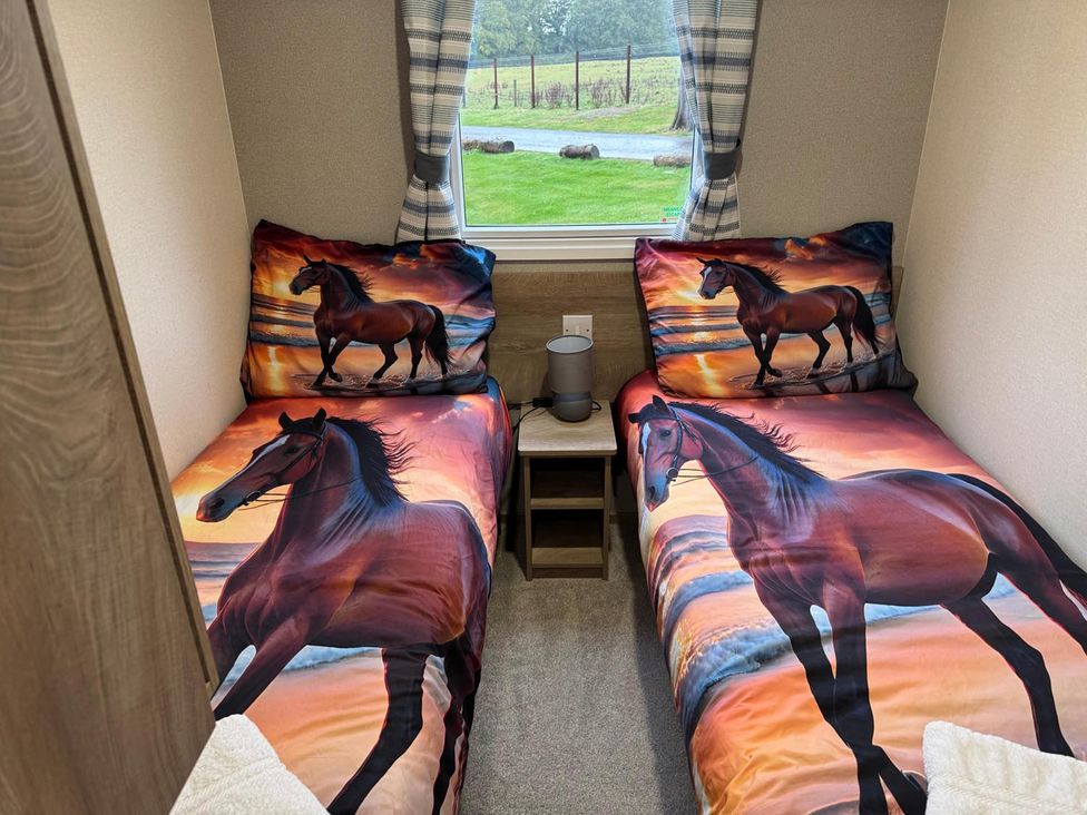 A bedroom with two beds and a window at West Lawn 47 Haggerston Castle Paddock Views Haggerston