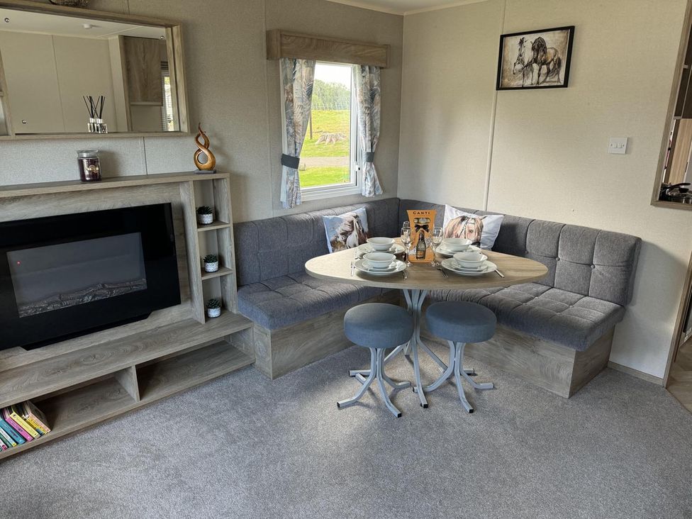 A living room with a sofa and dining table at West Lawn 47 Haggerston Castle Paddock Views Haggerston
