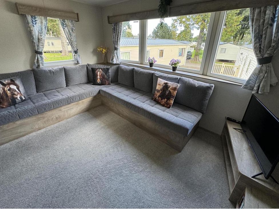 A living room with a corner sofa and television at West Lawn 47 Haggerston Castle Paddock Views Haggerston