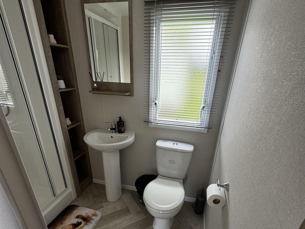 A bathroom with a shower, toilet, and sink at West Lawn 47 Haggerston Castle Paddock Views Haggerston