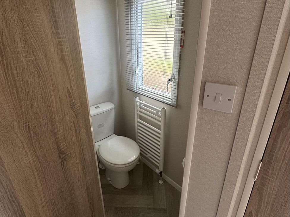 A bathroom with a toilet and radiator at West Lawn 47 Haggerston Castle Paddock Views Haggerston