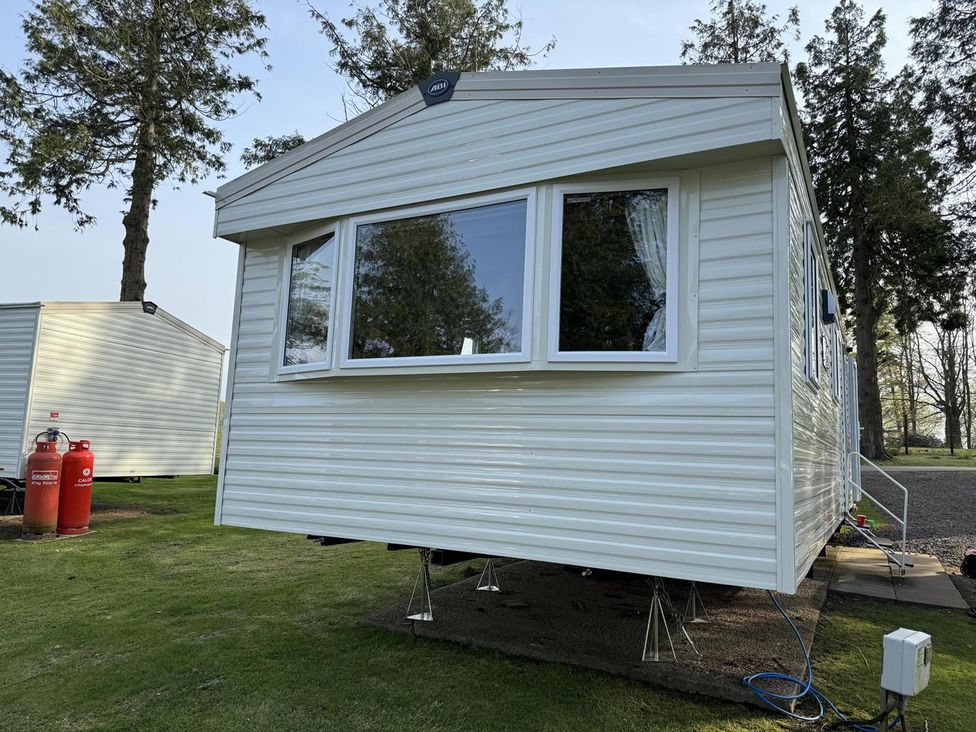 A caravan with large windows and gas cylinder at West Lawn 47 Haggerston Castle Paddock Views Haggerston