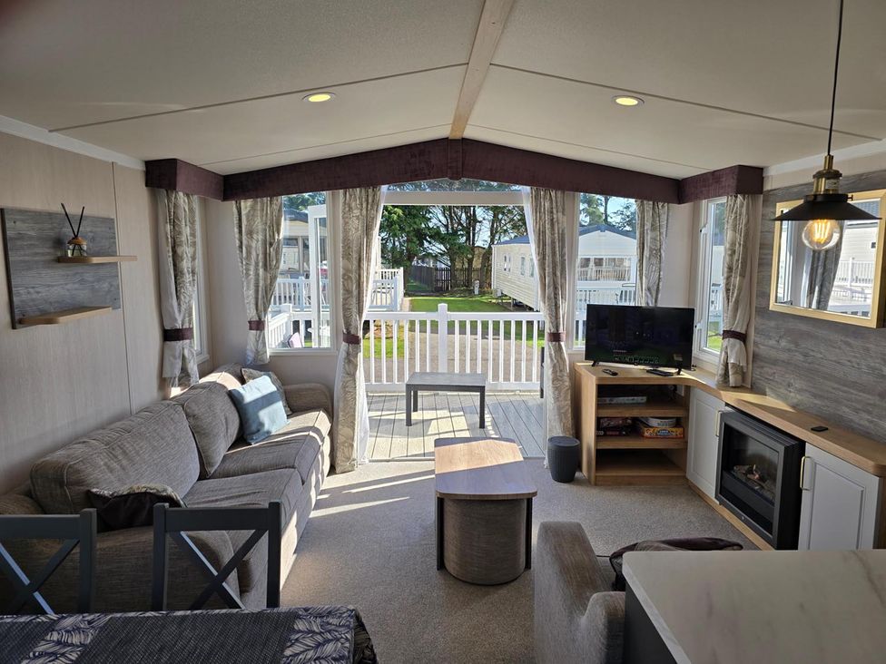 A living room with a sofa and television at 3 Bed-Sleeps 8-Free Parking-5 Min to Beach Embo near Dornoch