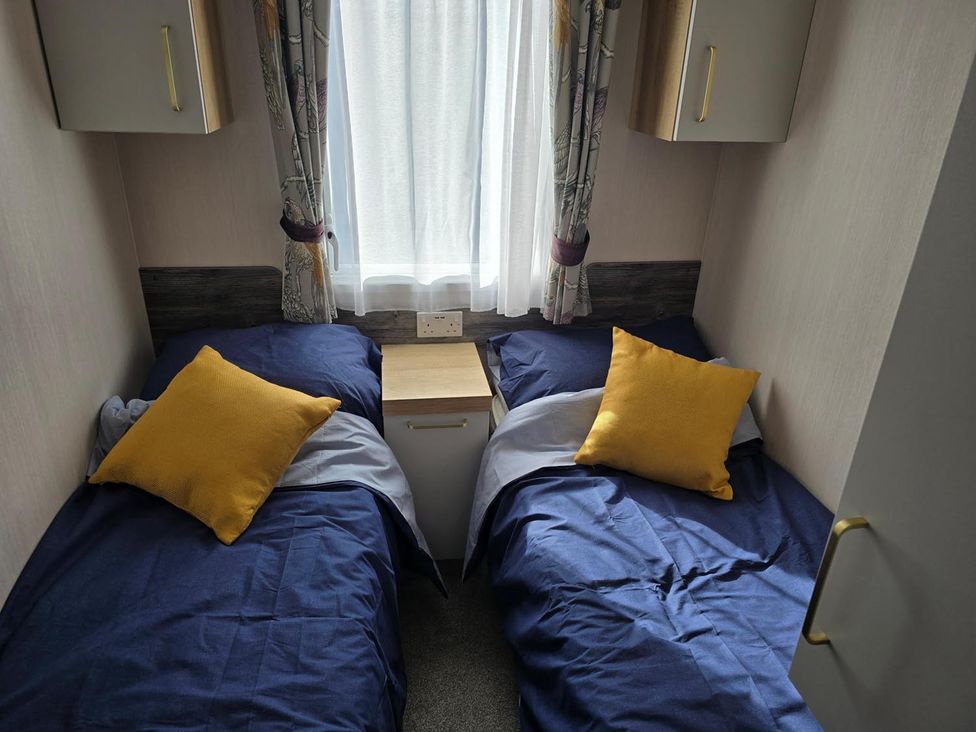 A bedroom with two beds and a side table at 3 Bed-Sleeps 8-Free Parking-5 Min to Beach, Embo near Dornoch