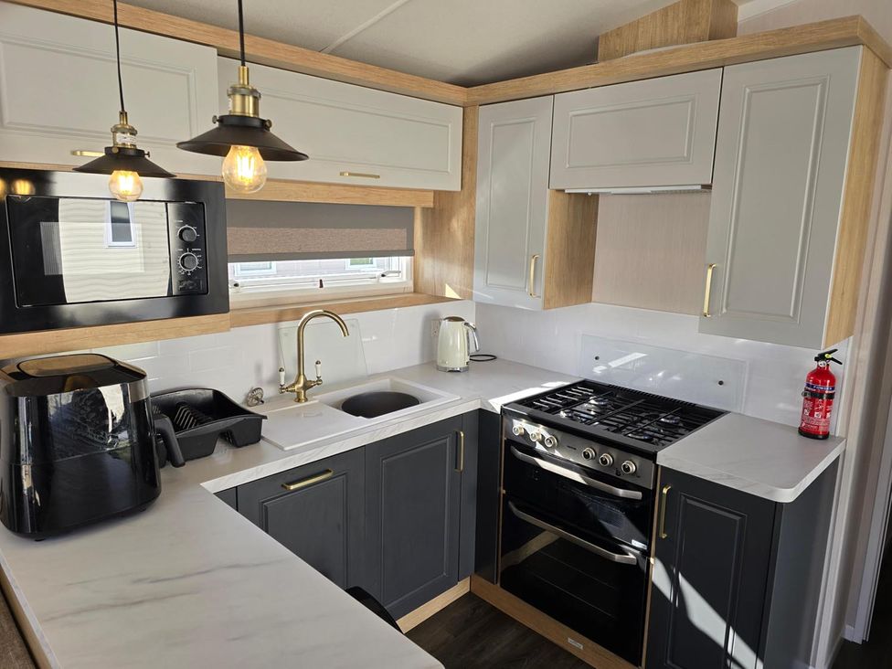 A kitchen with appliances and cabinetry at 3 Bed-Sleeps 8-Free Parking-5 Min to Beach in Embo near Dornoch