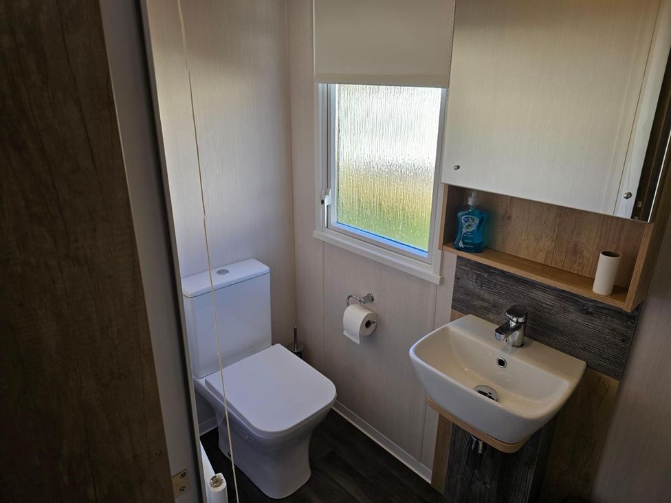 A bathroom with a toilet and sink at 3 Bed-Sleeps 8-Free Parking-5 Min to Beach Embo near Dornoch