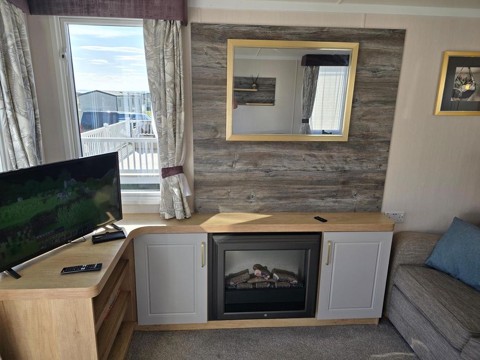 A living room with a television and a fireplace at 3 Bed-Sleeps 8-Free Parking-5 Min to Beach Embo near Dornoch