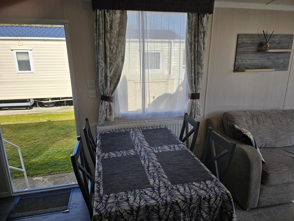 A dining area with a table and chairs at 3 Bed-Sleeps 8-Free Parking-5 Min to Beach in Embo near Dornoch