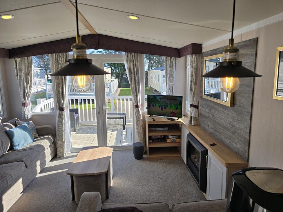A living room with a sofa, coffee table, and television at 3 Bed-Sleeps 8-Free Parking-5 Min to Beach in Embo near Dornoch