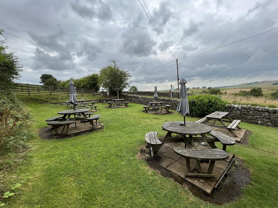 An outdoor area with tables and chairs at Milecastle Inn on Hadrian's Wall near Haltwhistle