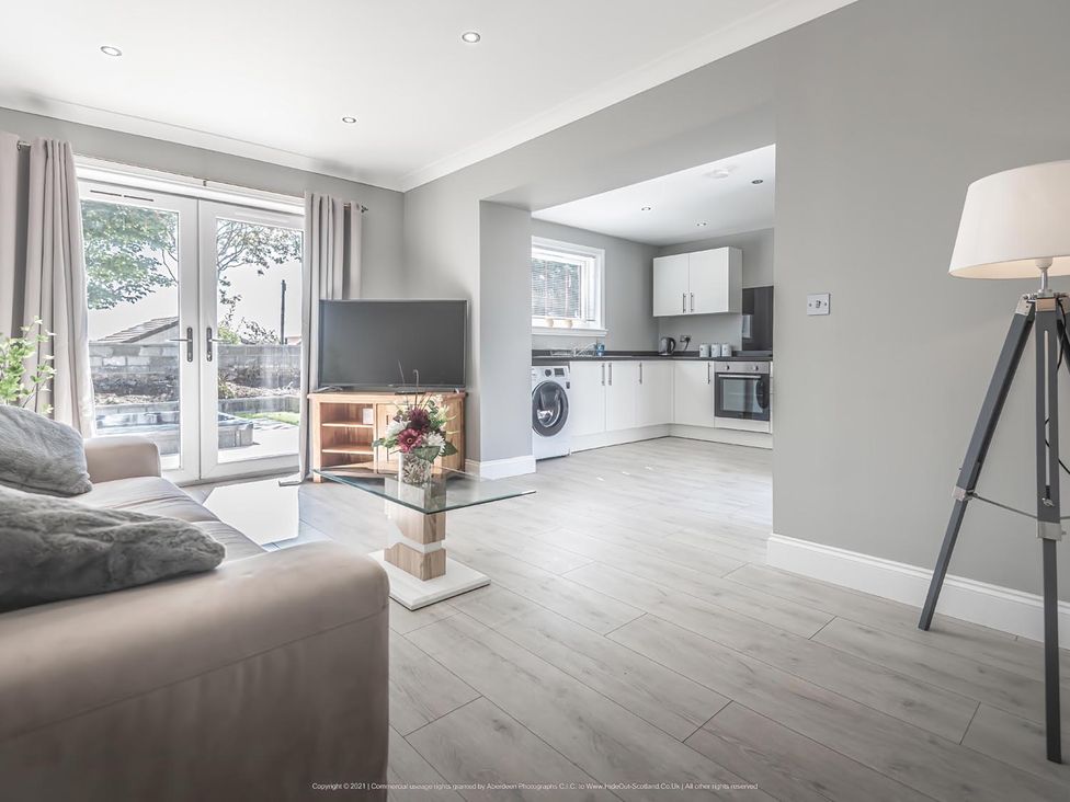 A living room with a sofa and television at 1 Bed Cottage-Sleeps 2-Parking-Pets-Hot Tub, Kelty