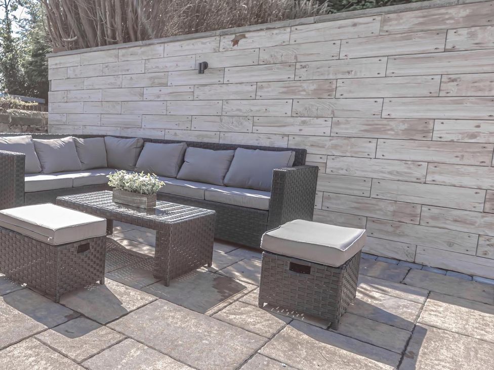 An outdoor seating area with a sofa, table, and ottoman at 1 Bed Cottage-Sleeps 2-Parking-Pets-Hot Tub, Kelty