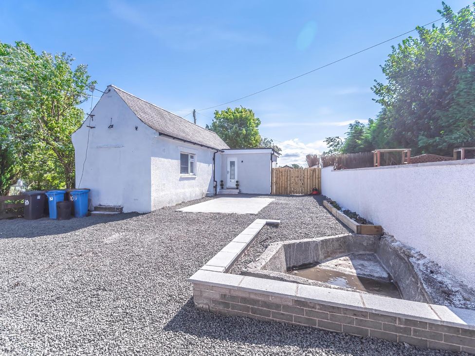 An outdoor area with a house and gravel space at 1 Bed Cottage-Sleeps 2-Parking-Pets-Hot Tub in Kelty