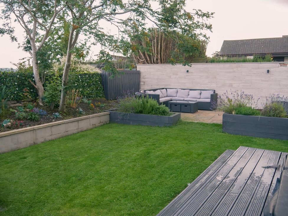 A garden with grass and a sofa at 1 Bed Cottage-Sleeps 2-Parking-Pets-Hot Tub in Kelty