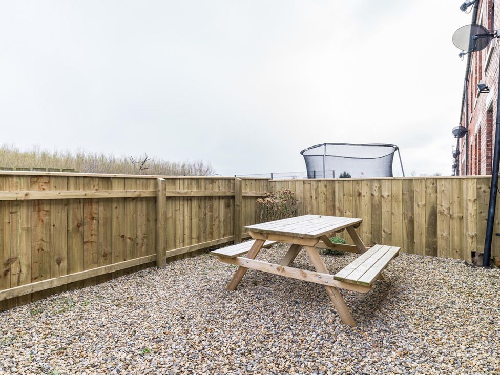 A garden with a picnic table and trampoline at East House-Sleeps 5-Pet friendly-Garden-Parking in Stakeford