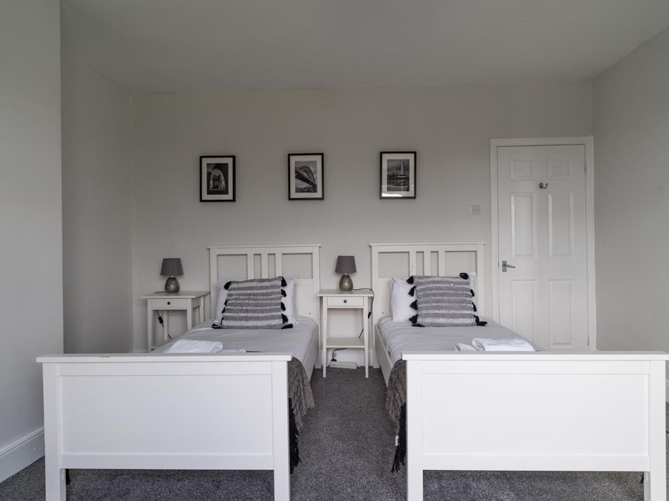 A bedroom with two beds and bedside tables at East House-Sleeps 5-Pet friendly-Garden-Parking in Stakeford