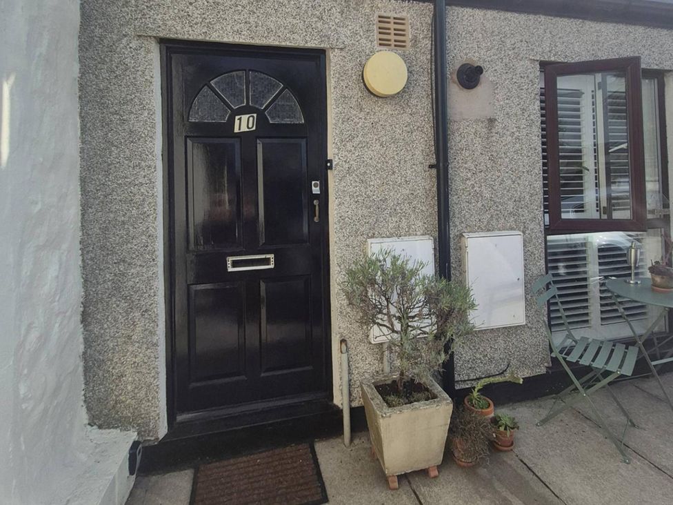 An entrance with a black door and plant pot at Stylish Cornish Retreat, Sleeps 4 Near Hayle Beach, Hayle