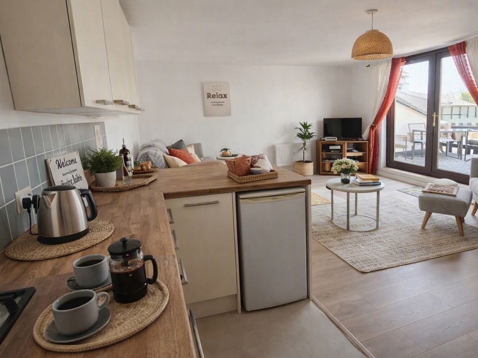 A kitchen area with a coffee setup and living area at Stylish Cornish Retreat, Sleeps 4 Near Hayle Beach in Hayle