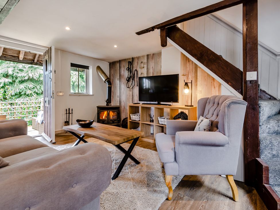 A living room with a wooden coffee table and television at Cottage - Sleeps 4 - Parking Evesham