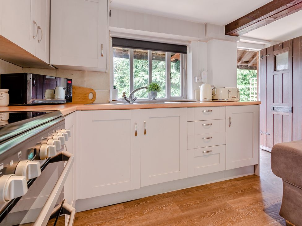 A kitchen with a stove and microwave at Cottage - Sleeps 4 - Parking in Evesham