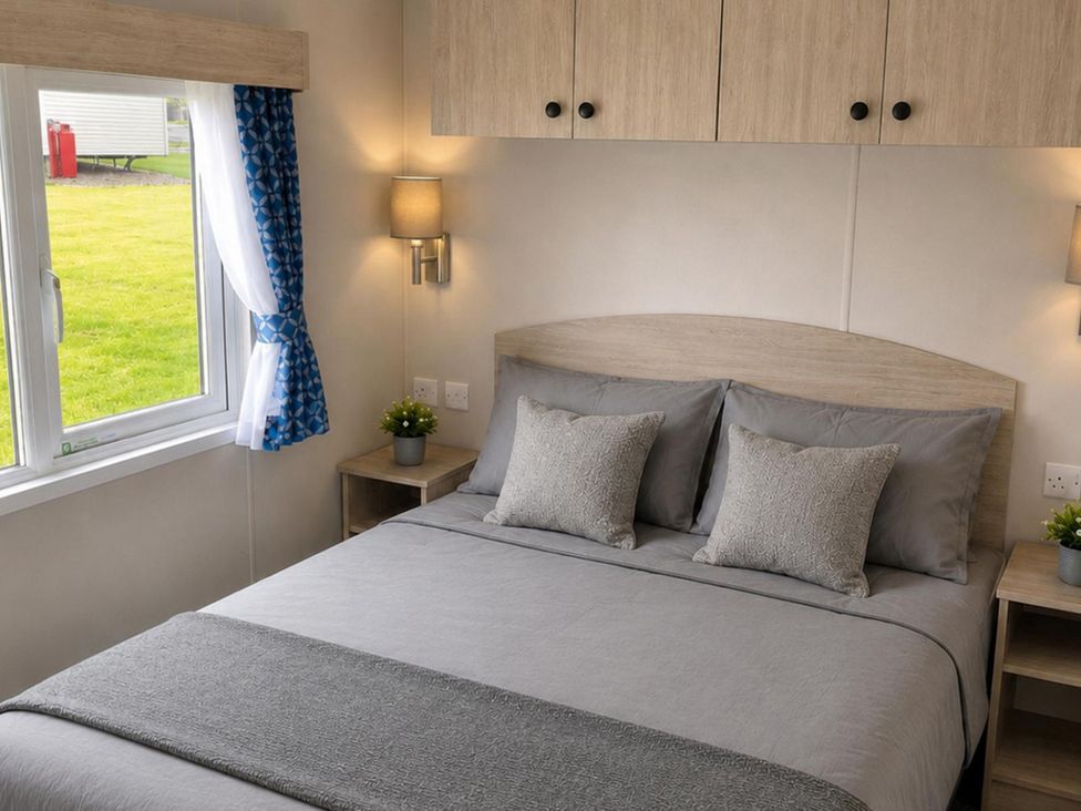 A bedroom with a bed and bedside table at 3 Bedroom Cabin Sleeps 6 - Shared Pool & Shared Hot Tub, Flamingo Land Resort near Malton