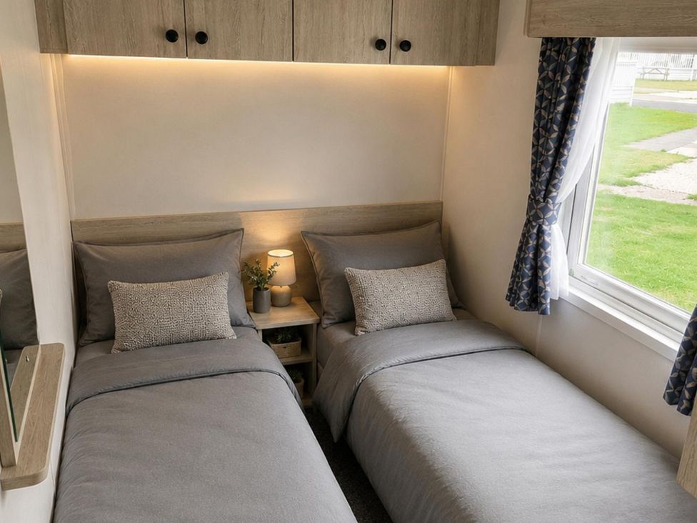 A bedroom with two beds and a lamp at 3 Bedroom Cabin Sleeps 6 - Shared Pool & Shared Hot Tub, Flamingo Land Resort near Malton