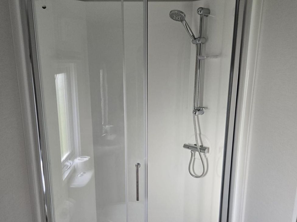 A shower with a showerhead and a soap dish at 3 Bedroom Cabin Sleeps 6 - Shared Pool & Shared Hot Tub, Flamingo Land Resort near Malton
