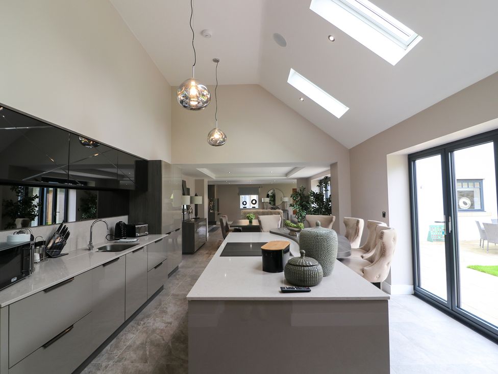 A kitchen with an island and chairs at Northumberland Luxury Stays - The Chivits, West Chevington near Amble