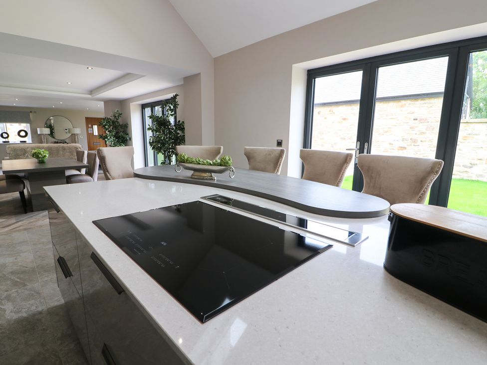 A kitchen with a cooktop and dining area at Northumberland Luxury Stays - The Chivits West Chevington near Amble